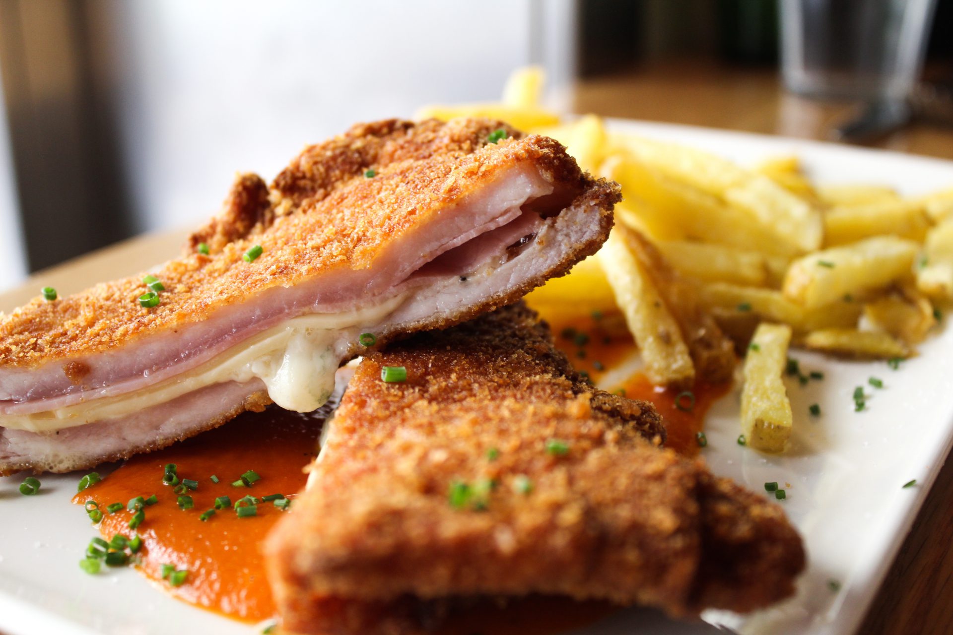 Lomo empanado relleno de jamón y queso acompañado de patatas fritas y salsa de tomate casera