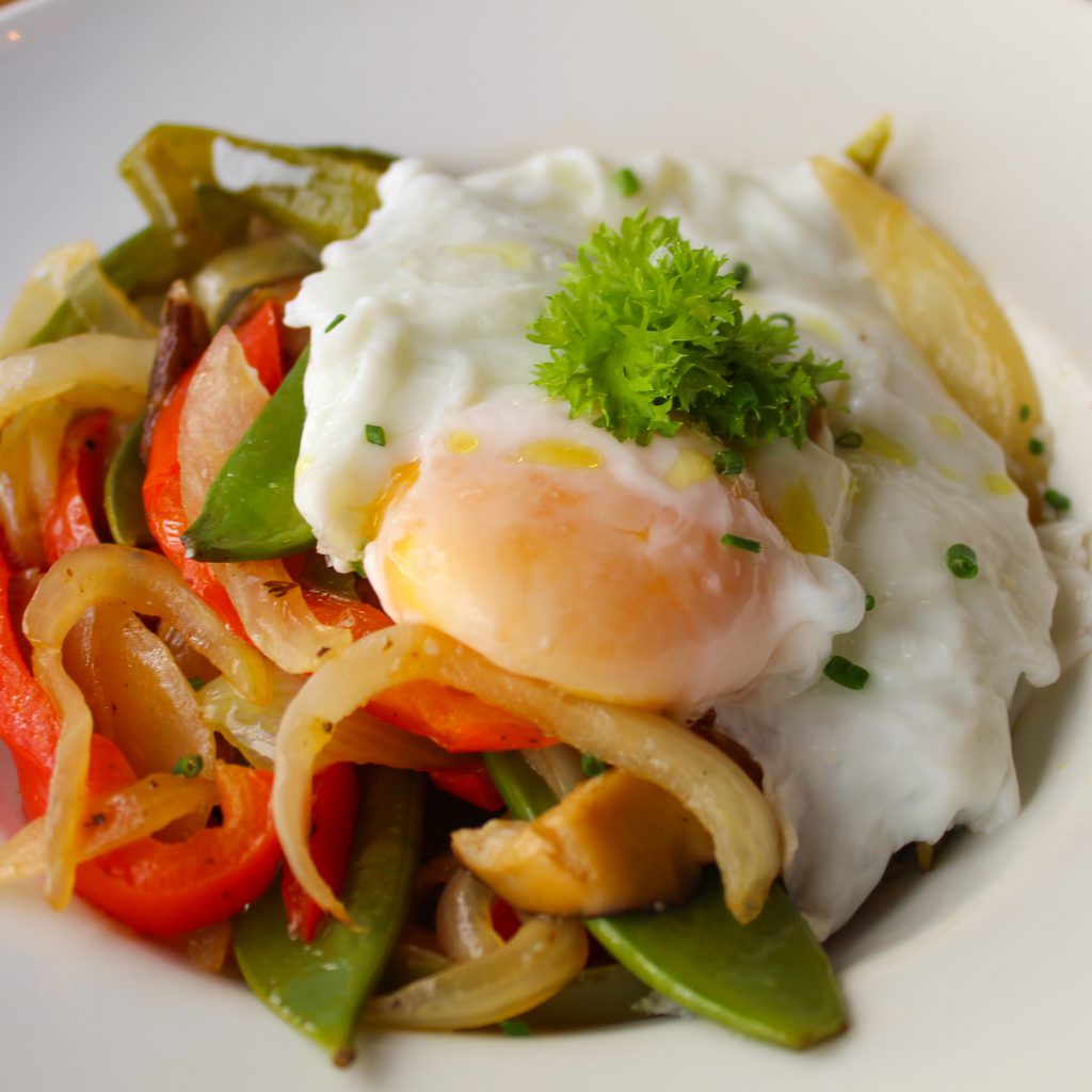 Verduras de temporada salteadas acompañadas de huevo poché