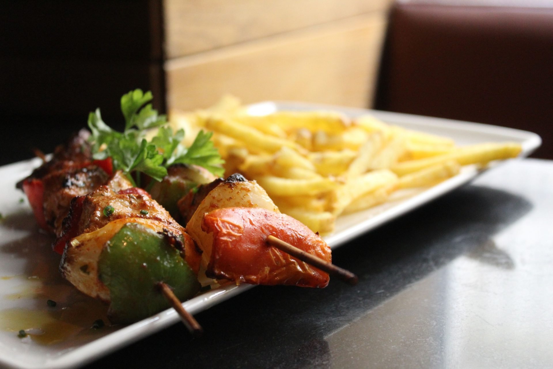 Brocheta de pollo marinado y verduras acompañado de patatas fritas