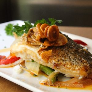 Merluza sobre verduras salteadas con refrito de ajo y pimentón