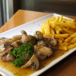 Pollo cocinado en su jugo con salsa de champiñón y patata fritas